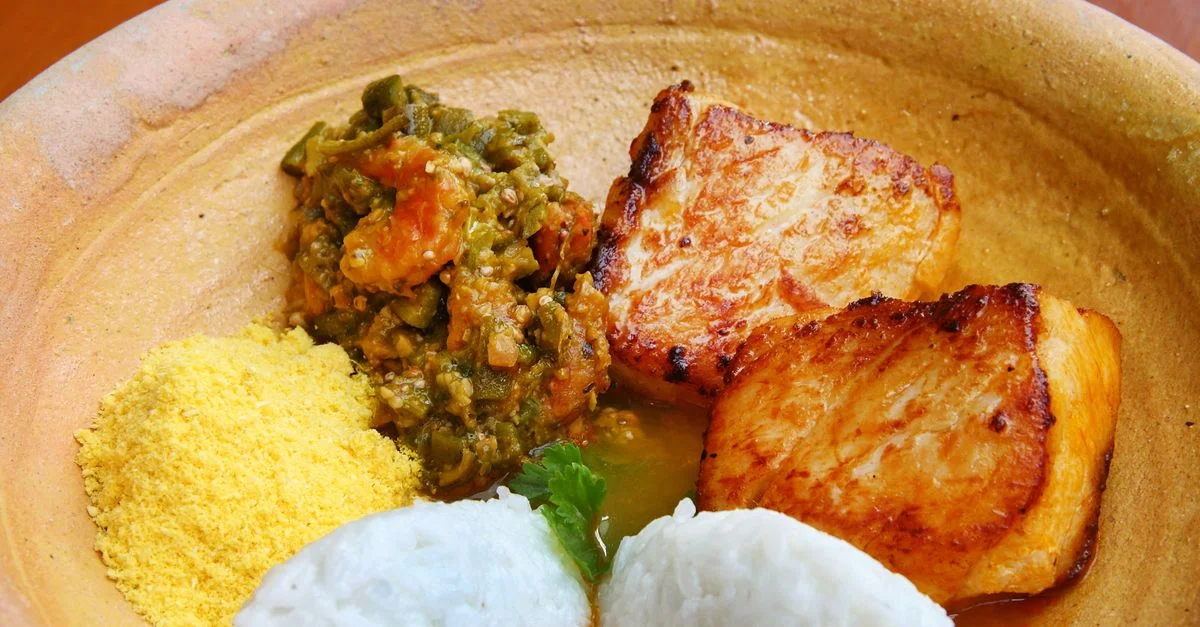 Gros plan de filet de poisson grillé avec du riz, du couscous et des légumes dans une assiette en terre cuite.